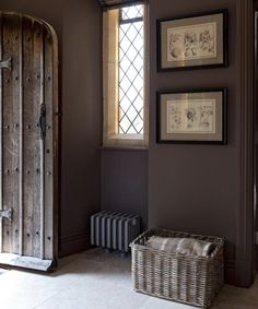 a room with some pictures on the wall and a basket in front of it that is next to an open door