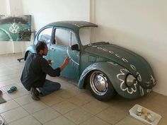 a man is painting the side of a car