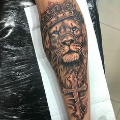 a lion with a crown tattoo on his arm