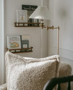 a living room with a chair, lamp and bookshelf on the wall above it