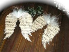 two angel wings with white feathers and music sheets on them, sitting on a wooden table