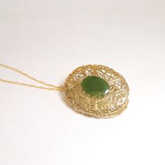 "A large and elegant vintage floral filigree oval locket is set with a gorgeous green jade stone.  There are two removable photo frames ready for pictures!   I have added a new long length 14kt gold fill rope chain to the pendant measuring 30.\"  Metal on the locket is gold plated.  Very good vintage condition, please see photos for visual details. Find similar jewelry HERE:  https://www.etsy.com/shop/freshyfig" Formal Green Locket Jewelry, Antique Green Locket Necklace, Vintage Green Filigree Jewelry, Vintage Green Locket Necklace, Elegant Oval Pendant Locket Necklace For Vintage Collection, Elegant Oval Pendant Locket Necklace From Vintage Collection, Elegant Green Jewelry With Vintage Charm, Vintage Jade Round Pendant Jewelry, Antique Oval Filigree Locket Necklace