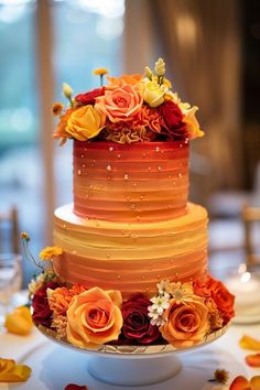 a multi - layered cake with flowers on the top is sitting on a white table