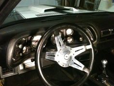 the interior of a car with black leather and chrome spokes, steering wheel and dashboard