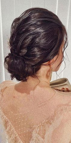 the back of a woman's head, with her hair in a low bun