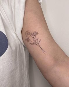 a woman's arm with a flower tattoo on the left side of her arm