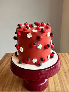 a red and white decorated cake sitting on top of a wooden table