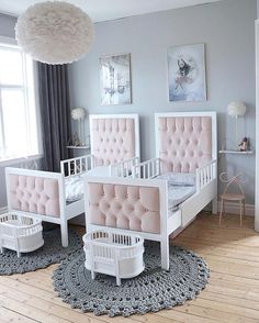 a bedroom with pink and white furniture on the floor, rugs in front of two windows