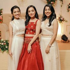 three women standing next to each other in dresses