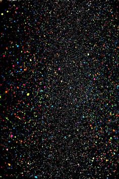 the sky is filled with multicolored confetti sprinkles and black background