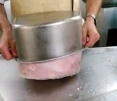 a person is holding a metal pan on a table