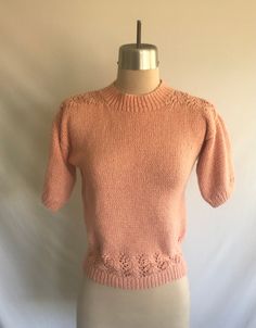 a mannequin with a pink sweater on it