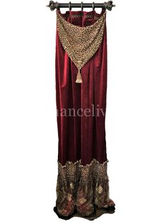 a red and gold dress hanging on a metal rod with an ornate tassell