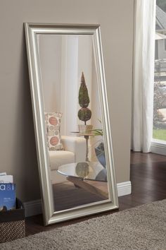 a large mirror sitting on top of a wooden floor