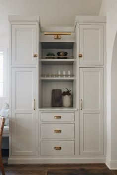 a white cabinet with gold handles and drawers