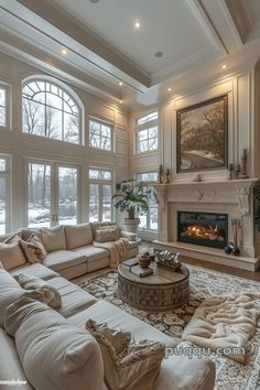 a living room filled with furniture and a fire place in front of two large windows