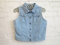 "Vintage Light Blue Denim Vest Womens Denim Vest Sleeveless Jeans Jacket Country Western Vest Medium Size N.B. Color may slightly differ from picture. Label size: 42, estimated size: Medium Measurements (taken laying flat): Length (back): 19.5\" / 49.5 cm Bust (pit to pit): 20\"/ 51 cm Waist: 17.5'' / 44.5 cm Please check measurements to insure a proper fit. Remember to allow yourself some extra room for movement. You can compare these with something from your closet that fits you well. Condition: good Vintage Condition SHIPPING * I ship worldwide via Priority mail. * I ship from Europe, so please allow 2 to 4 weeks for the package to arrive if you live overseas. * Europe 5 - 10 business days. 237" Light Wash Denim Vest With Snap Buttons For Summer, Blue Denim Vest Top For Spring, Casual Fitted Sleeveless Denim Jacket, Fitted Sleeveless Denim Jacket, Fitted Sleeveless Denim Jacket Casual, Spring Denim Blue Vest With Snap Buttons, Casual Denim Sleeveless Vest With Snap Buttons, Casual Sleeveless Denim Jacket With Buttons, Sleeveless Denim Vest With Snap Buttons For Spring