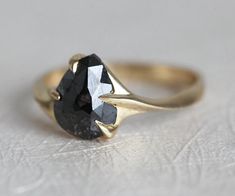 a black diamond ring sitting on top of a white surface