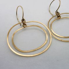 "Gold Oval Double Hoop Earrings ~ A modern retro take on the simple hoop dangle. Beautifully hand crafted of hammered gold fill wire, the two hoops move independently giving a subtle glimmer with every move you make. They are extremely light weight and perfect if you can't wear heavy earrings but like to wear a larger earring.  2\" length including the ear-wire and 1 5/8\" at the widest point. They fall just below the jawbone. Your purchase will arrive beautifully packaged in a floral jewelry bo Contemporary Round Earrings For Everyday, Contemporary Round Earrings, Contemporary Everyday Round Earrings, Modern Oval Hoop Earrings With Ear Wire, Modern Dangle Hoop Earrings For Anniversary, Modern 14k Gold Dangle Hoop Earrings, Modern 14k Gold Circle Earrings, Modern Anniversary Dangle Hoop Earrings, Modern Brass Hoop Earrings For Anniversary