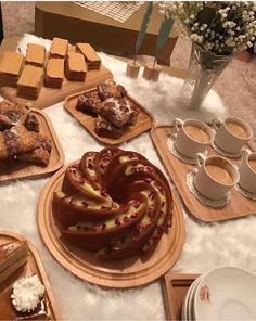 a table topped with lots of different types of cakes and desserts on trays