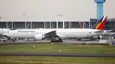 an airplane is parked on the tarmac in front of a terminal with other planes