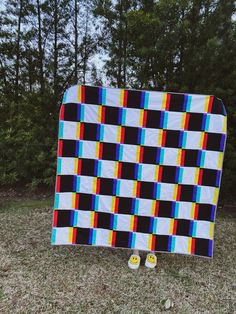 a blanket and pair of slippers sitting on the ground in front of some trees