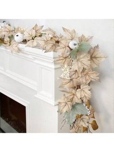 a white fireplace mantel with leaves and birds on it