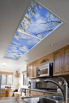 a kitchen with a skylight in the ceiling and wooden cabinets on the walls, along with stainless steel appliances