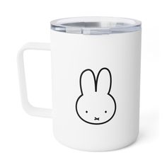 a white mug with a bunny face drawn on it