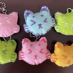 four different colored cat key chains on a table