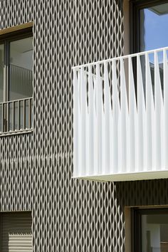 an apartment building with a white balcony and balconies