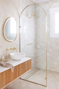 a bathroom with a sink, mirror and shower stall in the corner next to it