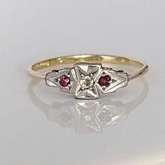 A beautiful understated ruby, diamond and platinum solid gold ring. The lovely rubies are a rich red in colour, complemented by a wonderfully bright old cut diamond which sparkles superbly in natural daylight. Perfect as a gift or for a special special occasion. ▪ Overall Condition: Excellent ▪ Metal: 18ct Gold & Platinum ▪ Gem: Ruby ▪ Gem: Diamond ▪ Gem Cut: Old & Round Cut ▪ Gem Colour: Red & White ▪ Ring Size UK: O.5 ▪ Ring Size US: 7.50 ▪ Marked: Stamped 18ct & Plat ▪ Resizing: Quotation Available ▪ Weight: 1.5gms ▪ Insurance Estimate: £735 ▪ Payment Layaway Plan Available: Yes ▪ Full Detailed Appraisal: Quotation Available As a qualified Gemmologist and Jeweller with over 20 years experience in the jewellery  industry, each jewel is chosen for its  'quality, beauty and interest'... As Vintage White Ruby Ring For Anniversary, Classic Red Diamond Ring With Single Cut Diamonds, Classic Red Ruby Ring With Single Cut Diamonds, Vintage Yellow Gold Ruby Ring Birthstone, Vintage Yellow Gold Ruby Birthstone Ring, Classic White Ruby Promise Ring, Red Ruby Ring With Single Cut Diamonds, Red Birthstone Ring With Rose Cut Diamonds, Antique Diamond Cut Ruby Ring For Anniversary