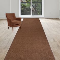 a chair sitting on top of a wooden floor in front of a large open window