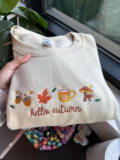 Hello Autumn Embroidered Sweatshirt! It couldn't be fall season without the perfect fall sweater! Embroidered on Gildan 50/50 Cotton/Polyester Blend. Using fall colors, our machine embroiders the cutest fall crewnecks! The perfect outfit for fall outings, watching movies, or going to the pumpkin patch! White Embroidered Logo Sweater For Fall, White Letter Embroidery Sweater For Fall, Cute Fall Hoodie, White Hoodie With Embroidered Graphics For Fall, Fall Embroidered Logo Long Sleeve Hoodie, Fall Hoodie With Embroidered Logo And Long Sleeves, Fall Long Sleeve Hoodie With Embroidered Logo, Casual Letter Embroidery Sweater For Fall, Casual Hoodie With Embroidered Logo For Fall