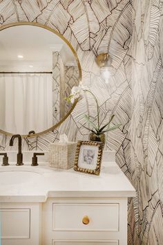 a bathroom with a mirror, sink and vanity in front of a wallpapered background