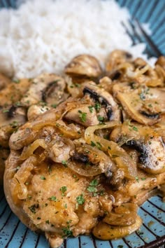 a blue plate topped with chicken, mushrooms and rice