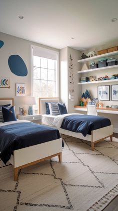 two beds in a bedroom with blue and white decor