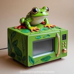 a green frog sitting on top of a microwave oven with leaves painted on the front