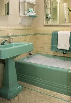 a bath tub sitting next to a sink under a mirror