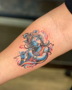 a woman's arm with a tattoo on it that has an image of a hindu god