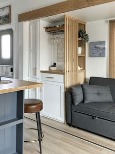 a living room with a couch, chair and kitchen island in the middle of it