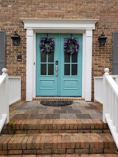 a blue front door with two wreaths on it