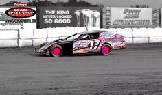 a pink and black car driving around a track