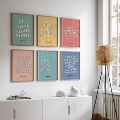 four framed posters on the wall above a white cabinet