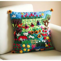 a colorful pillow sitting on top of a white chair