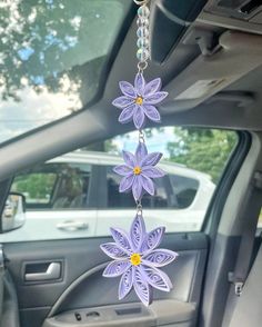 a purple flower hanging from the side of a car