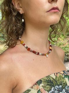 The Bonfire Necklace Ruby reds, golden browns, and sweet oranges compliment iridescent freshwater pearls and unique metallic beads.  Each necklace has a set of complimenting earrings to create a feeling of cohesiveness in any outfit. Diy Beaded Necklace, Orange Beaded Necklace, Necklace Ruby, Red Beaded Necklaces, Hippie Aesthetic, Orange Necklace, Bead Charms Diy, Beaded Necklace Diy, Boho Style Jewelry