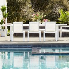 a table and chairs sitting next to a swimming pool