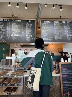 a person wearing headphones standing in front of a counter with menus on it